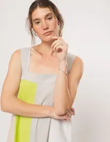 Vestido largo de lino color blanco, gris y amarillo, con breteles anchos, escote recto, elástico en la espalda y tajos laterales.