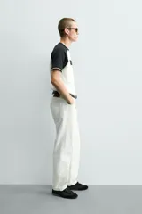 Camiseta de corte regular con diseño color block, cuerpo en color blanco y mangas ranglán en color negro. Presenta cuello redondo, detalles de rib a contraste en los puños y estampado frontal con la leyenda Mexico 70.
