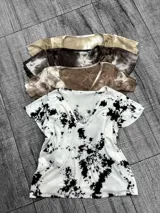 Remera blanca con estampado batik negro, corte clásico y cuello en V.