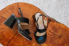 Sandalias de plataforma color crema, con tiras anchas de charol y hebilla ajustable en el tobillo.