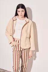 Campera beige de corderito vegano con cuello mao y cierre frontal con botones a presión.