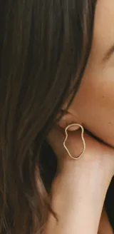 Aros colgantes dorados con forma irregular.