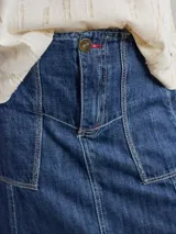Falda midi de denim azul con diseño de paneles, bolsillos frontales amplios y ruedo deshilachado.