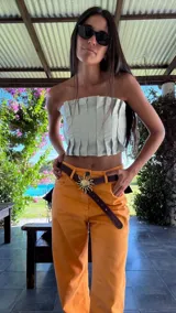 Top strapless de cuero color dorado, con diseño de tablas frontales estructuradas y elástico en la espalda.