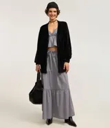 Cardigan largo de chenille con textura acanalada, manga larga y bolsillos delanteros. Presenta un diseño abierto y versátil, ideal para diversas ocasiones.