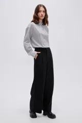 Pantalón negro de tiro alto, confeccionado en viscosa, de corte holgado y pernera ancha, con bolsillos laterales.