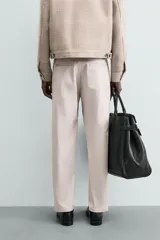 Pantalón chino de corte regular fit, confeccionado en tejido de algodón con elasticidad. Presenta bolsillos frontales, bolsillos traseros de vivo y cierre frontal con cremallera y botón.