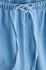 Pantalón de corte holgado en denim liviano de mezcla de lyocell y algodón, tiro alto con elástico revestido y cordón ajustable en la cintura, bolsillos laterales discretos y piernas rectas.