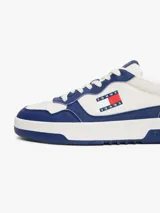 Zapatillas Tommy Jeans de corte bajo, confeccionadas en piel color blanco y azul con detalles en amarillo. Presentan suela cupsole, detalle de ventilación en la parte superior, logo de Tommy Jeans en relieve en la entresuela y parche de Tommy en el lateral.