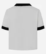 Cardigan de punto de manga corta con cuello redondo y cierre frontal de botones perolados. Presenta un diseño bicolor en blanco y negro con detalles de contraste en cuello, puños, tapetas de bolsillos frontales y vista central.