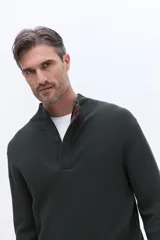 Buzo de tejido acanalado con cuello alto y apertura frontal con cierre, de calce cómodo y estructura limpia.