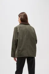 Campera de algodón estilo field jacket en color verde oliva, con cuello de pana en contraste color marrón, cierre frontal oculto y bolsillos delanteros amplios.