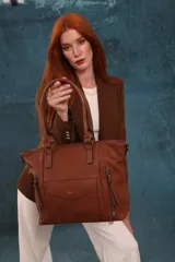 Cartera tipo tote de diseño estructurado en símil cuero, con doble asa rígida y correa regulable. Presenta múltiples bolsillos frontales con cierre y solapa, ofreciendo un estilo versátil y espacioso.