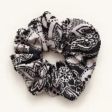 Colita de pelo estampada con diseño fruncido, ideal para recoger el cabello o usar como accesorio en la muñeca.