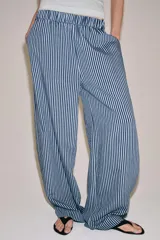 Pantalón de tiro medio con pierna ancha y cintura elástica, confeccionado en mezcla de viscosa con diseño de rayas verticales en tonos mostaza y marrón.