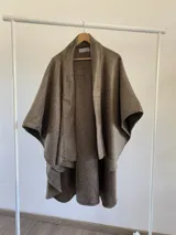 Ruana de diseño estructurado confeccionada en tela tipo tapiz, con solapas amplias y caída fluida, ideal para diversas estaciones.