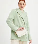 Bolso pequeño estructurado de poliuretano color blanco, con textura capitoneada, solapa frontal con botón a presión, divisor interno con cremallera y asa de cadena con detalle de medallas. Marca Satinato.