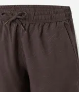 Bermuda deportiva de hombre color marrón, con cintura elástica ajustable mediante lazo y estampa heat print. Confeccionada en tejido de poliéster de secado rápido, diseñada para brindar comodidad y libertad de movimiento durante la actividad física.