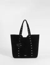 Cartera tipo shopper de gran tamaño confeccionada en material efecto gamuza color rojo. Presenta correas reforzadas decoradas con tachas metálicas plateadas y un dije colgante en forma de corazón con detalles de tachas. Cuenta con una placa metálica pequeña con logo en la parte inferior frontal.