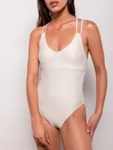 Malla entera color crema con textura acanalada, breteles dobles cruzados y anudados en la espalda.