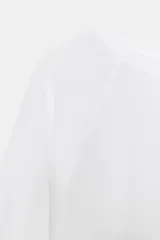 Camiseta de algodón con cuello redondo y mangas largas tipo ranglán. Presenta un corte regular y bajo recto.