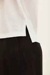 Remera blanca de algodón con cuello en V y mangas cortas.