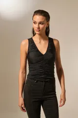 Top negro sin mangas de poliéster, con escote en V profundo y frunces en la parte delantera.