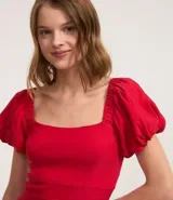 Vestido corto rojo de bengalina, ajustado al cuerpo, con escote cuadrado, mangas cortas abullonadas y elástico en la espalda.