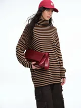 Polera de tejido de punto con diseño de rayas horizontales en tonos marrón y negro, cuello alto, mangas largas con hombros caídos y corte holgado.