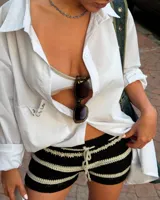 Shorts de crochet de tiro bajo, con diseño a rayas horizontales alternando negro y beige claro. Presenta cordón ajustable en la cintura.