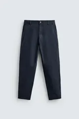 Pantalón de corte carrot fit confeccionado en tejido de algodón con estructura diagonal y efecto lavado. Presenta bolsillos frontales con bolsillo cerillero, bolsillos traseros de plastrón y cierre frontal con cremallera y botón.