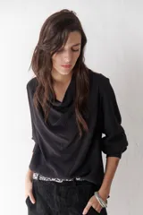 Blusa blanca de cuello buche y mangas largas con puño.
