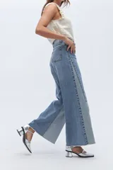 Jean wide leg de diseño bicolor en tonos de azul y celeste, confeccionado en denim de algodón. Presenta una silueta holgada, pierna ancha y pretina alta.