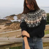 Sweater de punto con diseño de inspiración nórdica en el canesú, tejido en mezcla de alpaca. Presenta cuello redondo, mangas largas y un calce relajado, con una textura suave y ligera.