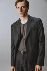 Blazer de corte regular confeccionada en lana de origen italiano, con diseño a cuadros sutiles. Presenta cuello con solapas de pico, cierre frontal de botones, bolsillos de solapa en la cadera y bolsillo de vivo en el pecho.