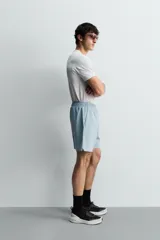 Pantalones deportivos cortos de tejido técnico ligero y elástico, con cintura elástica ajustable, bolsillos frontales y aberturas laterales en el bajo.