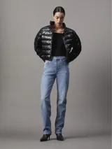 Campera puffer corta de nailon reciclado color negro, con cuello alto, cierre frontal con cremallera, bolsillos laterales con cremallera y logo de Calvin Klein en el pecho.