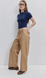Pantalón verde militar de tiro medio y calce wide leg, con bolsillos laterales y cierre frontal con botón.