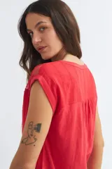 Blusa roja de algodón con cuello en V y detalle de encaje floral en el canesú.