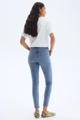 Pantalón de jean skinny de tiro alto, color celeste claro, con cinco bolsillos y cierre con botón.