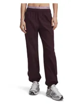 Pantalón deportivo Under Armour Unstoppable Wvn color bordó, de corte relajado, con cintura elástica con cordón de ajuste y puños elásticos en los tobillos.