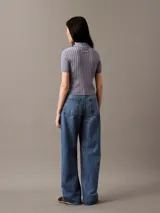 Pantalón de jean corte relaxed de pierna ancha, con diseño clásico de cinco bolsillos, cierre de botón y cremallera, en un lavado azul medio.