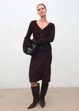 Cardigan de punto color marrón oscuro, con cuello en V, cierre frontal de botones, manga larga y diseño recto con lazo ajustable en la cintura.