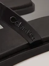 Sandalias Calvin Klein de goma color negro, con doble tira y logo en relieve.