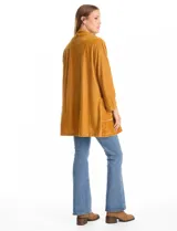 Blazer abierto de terciopelo color mostaza, con cuello solapa y diseño fluido de corte largo.