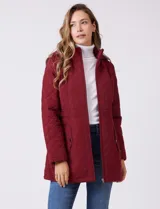 Campera capitoneada de largo midi en color bordó, con diseño de rombos en el cuerpo y mangas, y costuras diagonales en los laterales. Cuenta con cierre frontal, capucha desmontable con interior suave y panel entallado en la cintura.