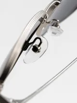 Lentes de sol con marco metálico negro y lentes rectangulares verdes.