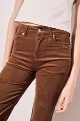 Pantalón de pana color beige, tiro medio, corte recto y largo al tobillo.