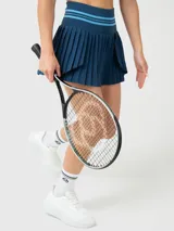 Conjunto deportivo de dos piezas color azul petróleo, compuesto por una musculosa de corte ajustado con cuello redondo y una pollera tableada con diseño plisado.