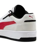 Championes Puma modelo Ferrari Court, de diseño urbano con base blanca, detalles en rojo y refuerzos de gamuza gris claro. Presenta el logo de Ferrari en la lengüeta y la icónica franja lateral de Puma en color rojo.